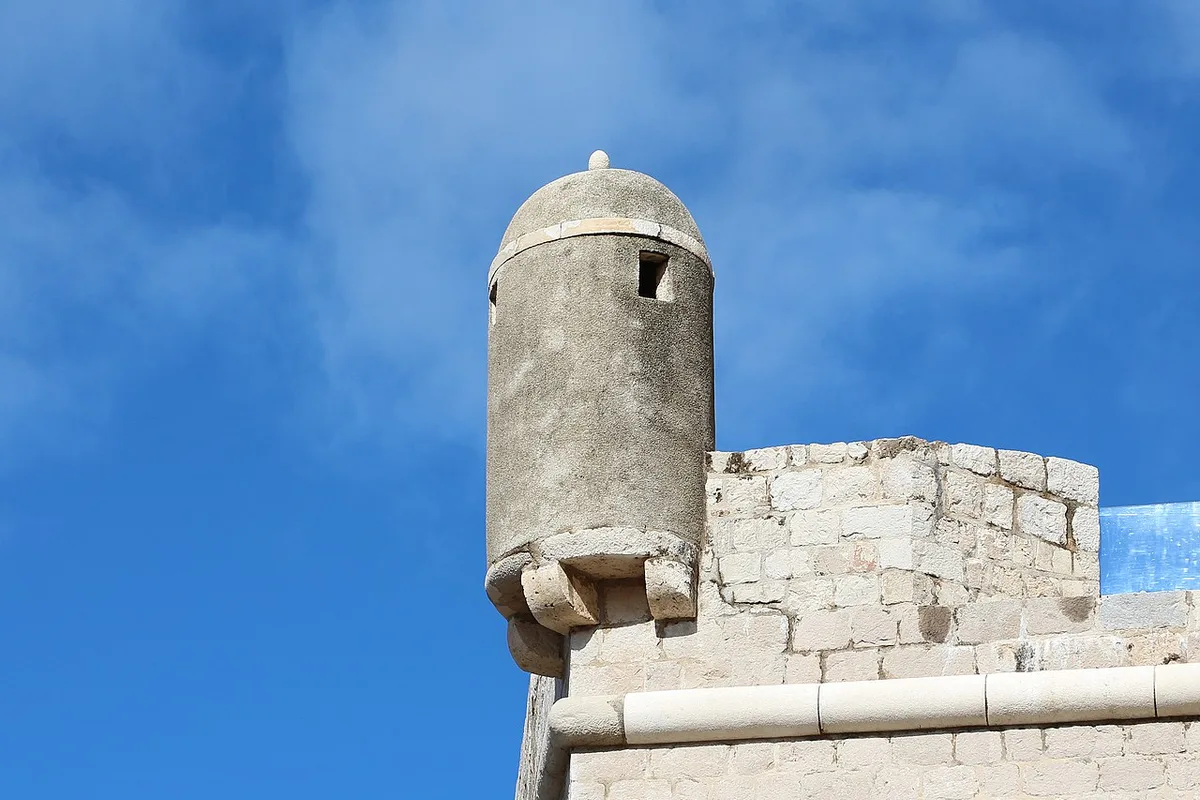 De oranje daken en middeleeuwse stadsmuren van Dubrovnik met de Adriatische Zee op de achtergrond