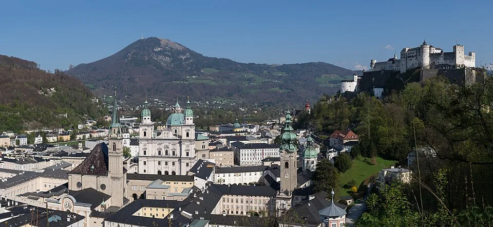 De Hohensalzburg vesting op de rots boven de barokke stad Salzburg met de Salzach rivier eronder