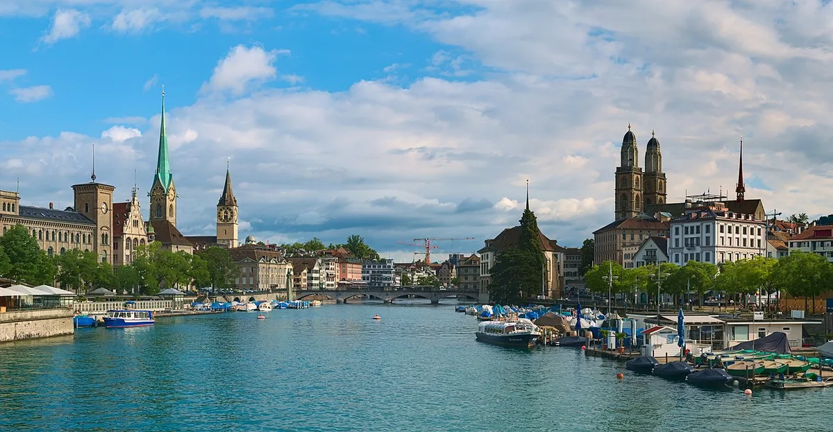 De historische Altstadt van Zurich weerspiegeld in de Limmat met de kerktorens op de achtergrond